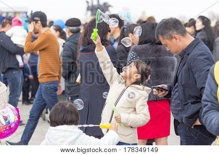 Shymkent, KAZAKHSTAN - 22 March 2017: People Celebrating the Kazakh holiday NARIYZ. Girl with soap bubbles .