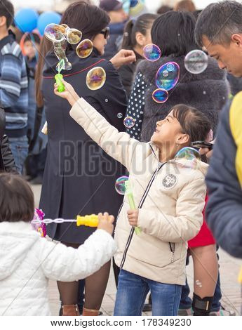Shymkent, KAZAKHSTAN - 22 March 2017: People Celebrating the Kazakh holiday NARIYZ. Girl with soap bubbles .