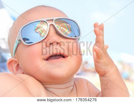 Adorable Happy funny smiling cute baby boy on the beach