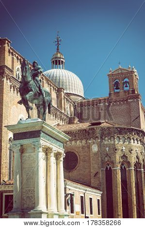 The Renaissance Equestrian Statue of Bartolomeo Colleoni (1483) is one of the most beautiful and big equestrian statues in the world. Basilica dei Santi Giovanni e Paolo is in the background. (Venice Italy) Edited as a vintage photo with dark edges.