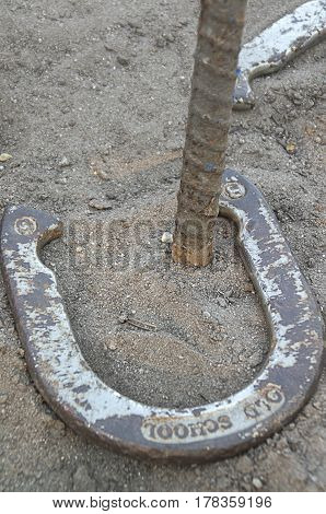 A horseshoe lays around the post scoring a ringer in the game of Horseshoes