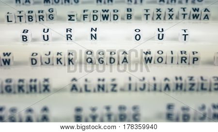 Burn out cube letters highlighted out between other blurred lettters.