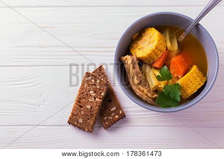 Puchero Soup With Corn And Parsley On Wooden Table