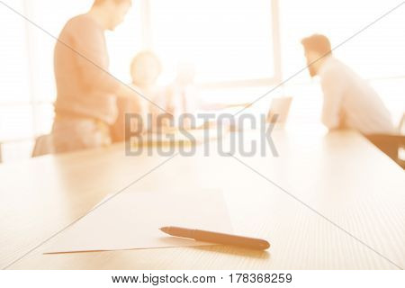 Toned of interview in office. Contract for work concept. Focus on contract for new worker. Freelancer and businessmen represented on background.