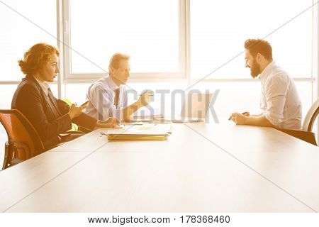 Toned of job interviewer giving his CV to be admitted to huge company, firm, enterprise. Handsome man communicating with employees in board room in office.