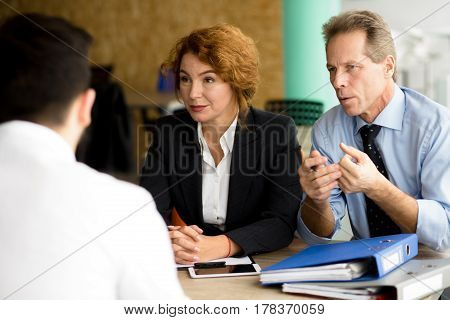 Business people of one company having negotiations with business partners in board room in office. People discussing burning business issues.