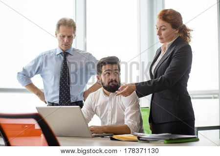 Mobbing, stress, work, scandal concepts. Angry boss lady showing her worker something on laptop computer while staying in board room in office.