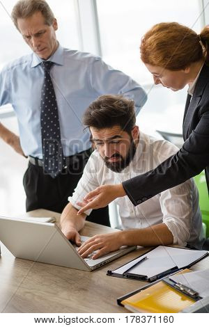 Mobbing, stress, work, scandal concepts. Angry boss lady screaming and shouting at her executive worker while he is using laptop computer for business purposes.