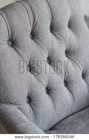 Seamless background texture close up of a grey sofa back with button detail on a thick cloth