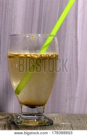 A glass of a summer drink Jal zeera or cumin lemonade with spices on a wooden background selective focus.