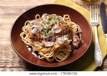 Plate with delicious chicken marsala and spaghetti on table
