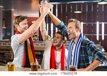 Happy men highfiving in a bar