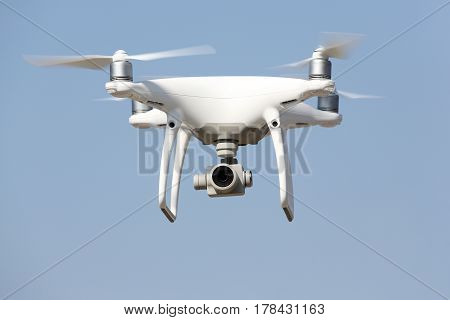 KAGAWA, JAPAN - MARCH 17, 2017: White remote controlled Drone Dji Phantom4 Pro equipped with high resolution video camera hovering in air and blue sky in the background