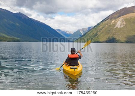 Man paddling kayak in mountain lake, Lake Rotoiti, New Zealand