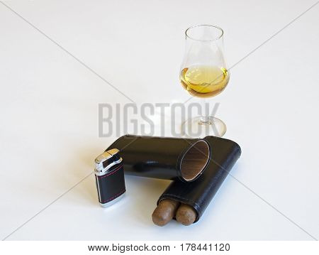 Glass of whiskey and two cigars leather black cigar lighter on a white background