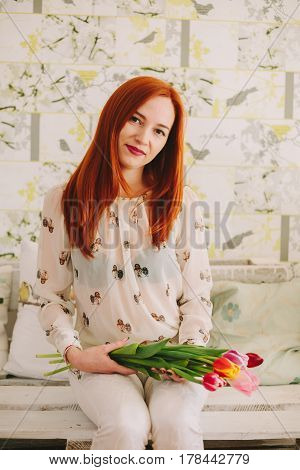 red-haired girl holding a bouquet of tulips