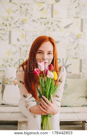 red-haired girl holding a bouquet of tulips