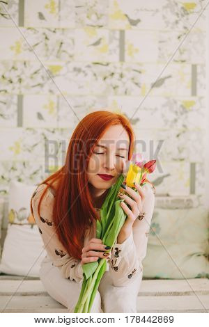 girl hollding a bouquet of tulips .