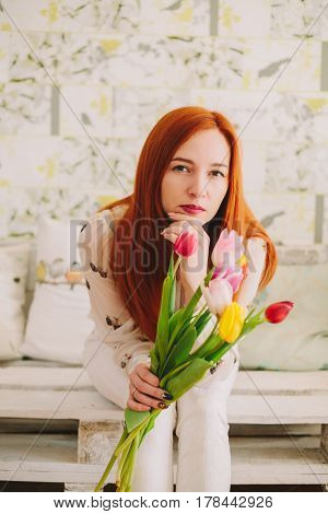 red-haired girl hollding a bouquet of tulips