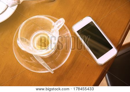 Smartphone On The Table With Empth Glass Cup Of Coffee