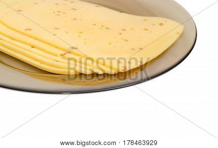 Fragment of the several slices of semi-hard cheese made with the addition of the crushed walnuts on a dark glass dish closeup on a light background