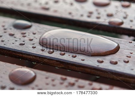 Water drops raindrops pattern on wooden table planks. Shallow depth of field.