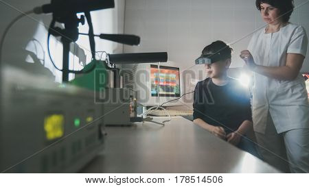 the doctor checks the child's vision with the help of stereovideo virtual reality glasses, wide angle