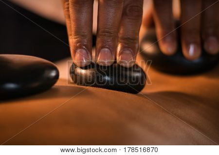 Closeup of massage with hot stones. Spa treatment.