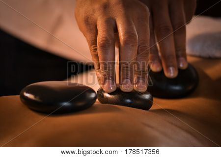 Closeup of massage with hot stones. Spa treatment.