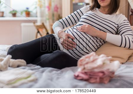 Pregnant woman with big belly at home.
