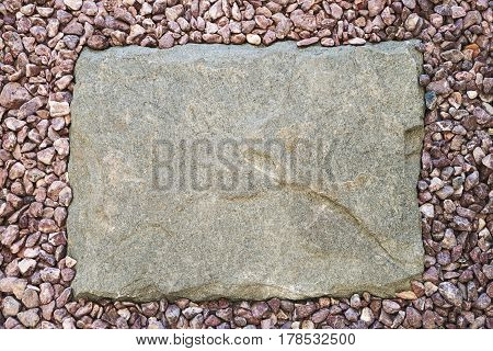 Stone slab around a pebble frame, top view with copy space.