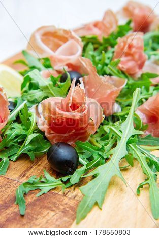 Chopping Board With Aragula And Raw Ham