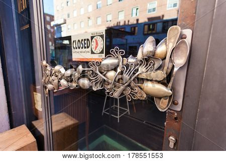 MILAN ITALY - September 12 2016:Unusual cafe's door handle made from vintage forks and retro spoons and the sign with the inscription 