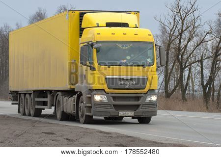 ST. PETERSBURG, RUSSIA - MARCH 09, 2017: Yellow truck MAN TGS of 2008 model year with the semi-trailer on the highway in the gloomy March afternoon