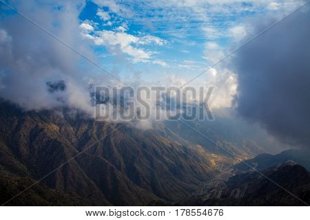 The Sun behind the clouds over mountains