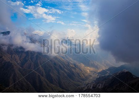 The Sun behind the clouds over mountains