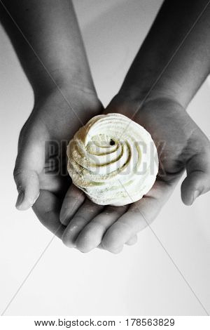 Marshmallow (zephyr) in woman's hand. zephyr in hands