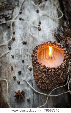 Burning Aromatic Coffee Candle And Coffee Beans On Aged Wood