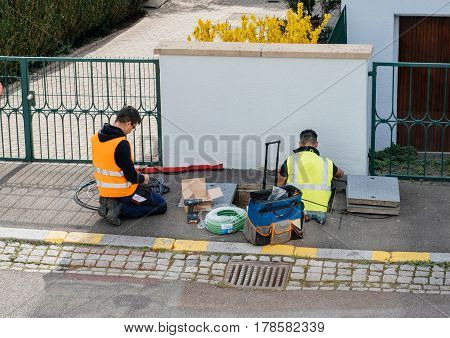 PARIS FRANCE - MAR 24 2017: Team of workers from telecomunication internet provider company working on implementation of fiber optic cables in sewage system - aerial view