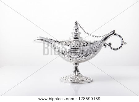 Silver alladdin lamp on white background.