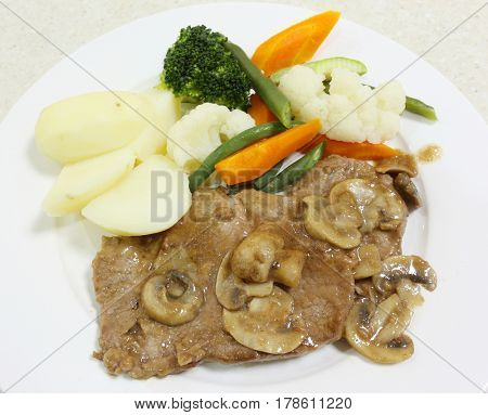 Roast beef served with a mushroom gravy, boiled potatoes and steamed vegetables, from above