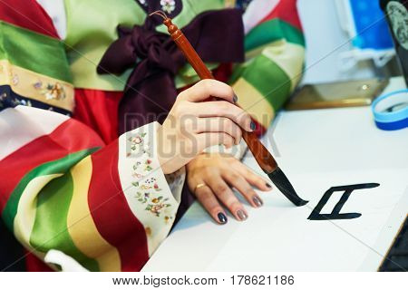 Calligraphy. Female hand writing Korean hieroglyph