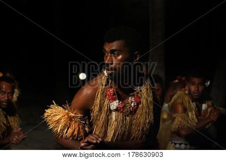 Indigenous Fijian men dancing a traditional male dance meke wesi the spear dance. Real people copy space