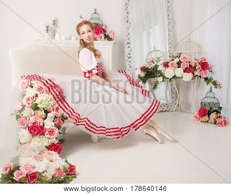 Pretty ballerina in stage costume next to bouquets of spring flowers. Retro dress.