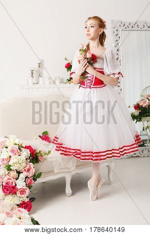 Pretty ballerina in stage costume holding a bouquet of spring flowers. Retro dress. She dreams.