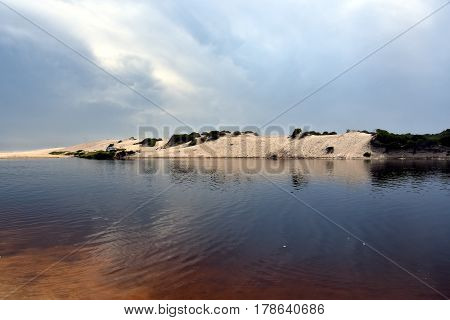 Crokers creek with sand dunes in the background (Belmont - Nine Miles - Beach NSW Australia).
