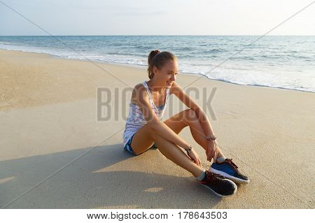 Young girl resting after exercise on the beach