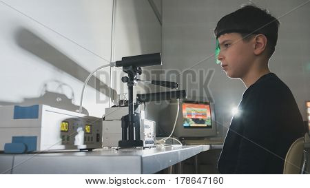 Ophthalmology clinic - child checks eyes vision with high technology device, close-up