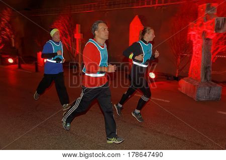 STOCKHOLM SWEDEN - MAR 25 2017: Group of runners in a tunnel with red light and grave stones the Stockholm Tunnel Run Citybanan 2017. March 25 2017 in Stockholm Sweden