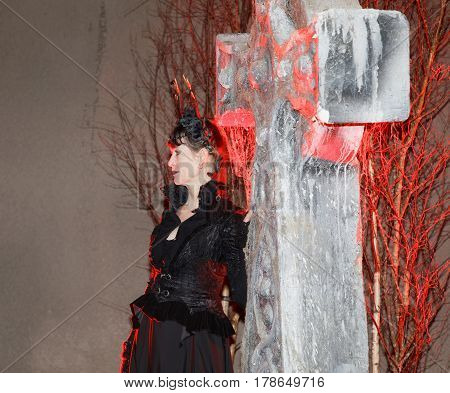 STOCKHOLM SWEDEN - MAR 25 2017: Woman in black dress looking like a vampire in red light leaning on a tomb stone in the Stockholm Tunnel Run in the Stockholm Tunnel Run Citybanan 2017. March 25 2017 in Stockholm Sweden